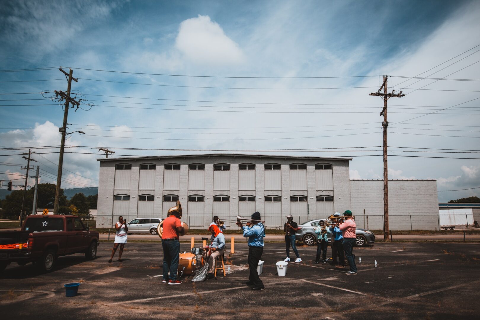 A group of people standing in the parking lot.