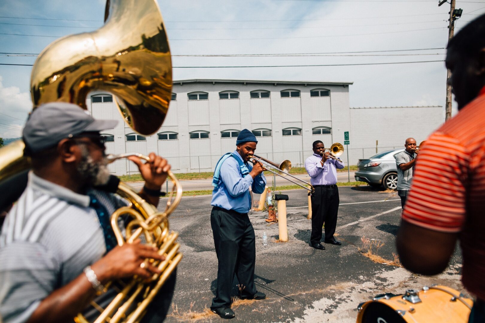 A group of people playing brass instruments in the street.