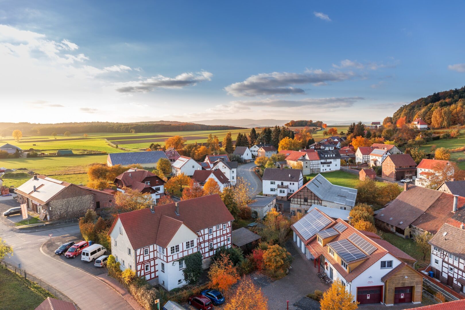 A view of houses and cars in the fall.